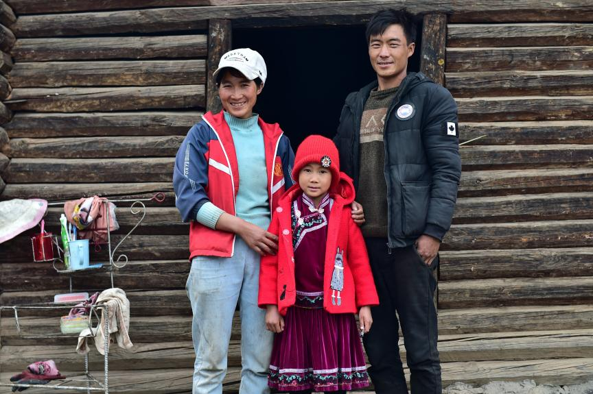 Xiao Hua and her parents in front of their house in Lanping